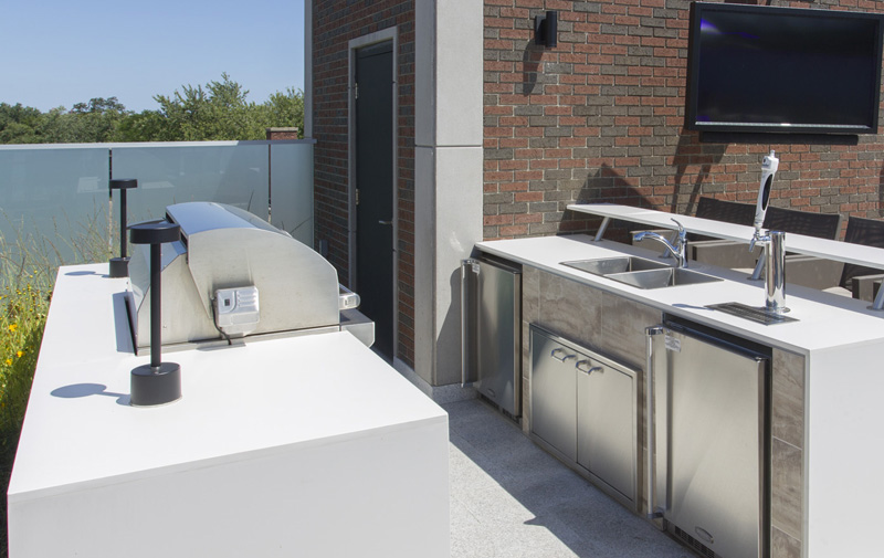 The outdoor kitchen is complete with BBQ, fridge, sink, tap, and outdoor beverage dispenser.